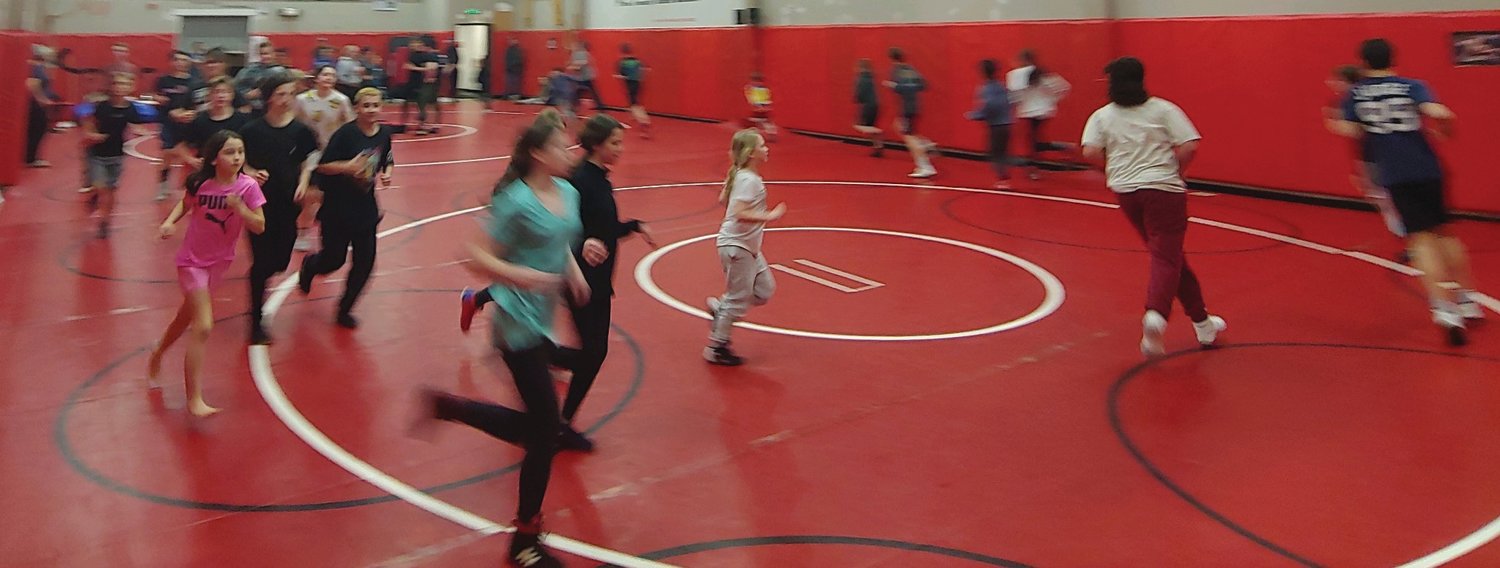 Josi Wiley (in white) and Anglie Luckhurst (in pink) train with the middle school wrestling team a couple times a week to try out for wrestling.  Approximately a dozen youth showed up for the introductory wrestling sessions.  Combined with the middle school team, nearly 40 kids filled the room on March 15.  Drop-ins are welcome for youth wrestling.
